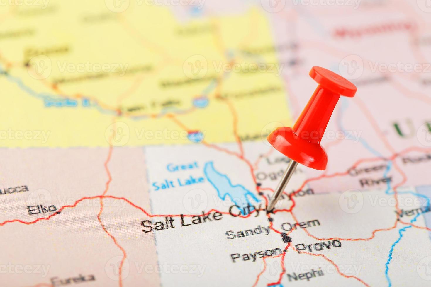 Red clerical needle on a map of USA, Utah and the capital Salt Lake City. Closeup Map Utah with Red Tack photo