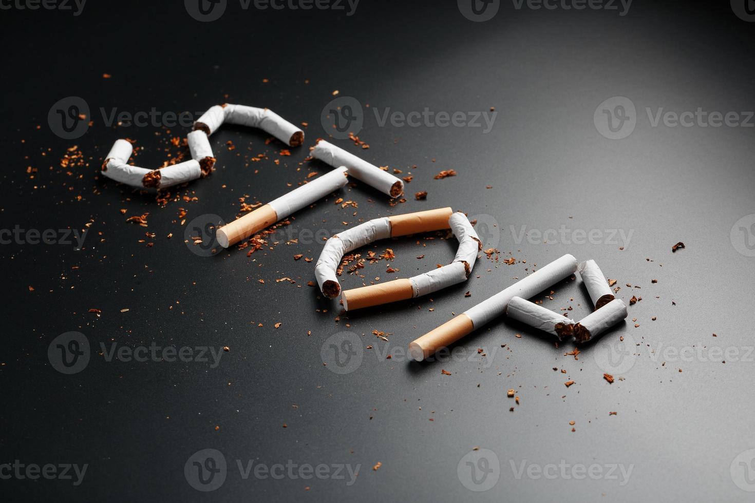 The inscription STOP from cigarettes on a black background. Stop smoking. The concept of smoking kills. Motivation inscription to quit smoking, unhealthy habit. photo