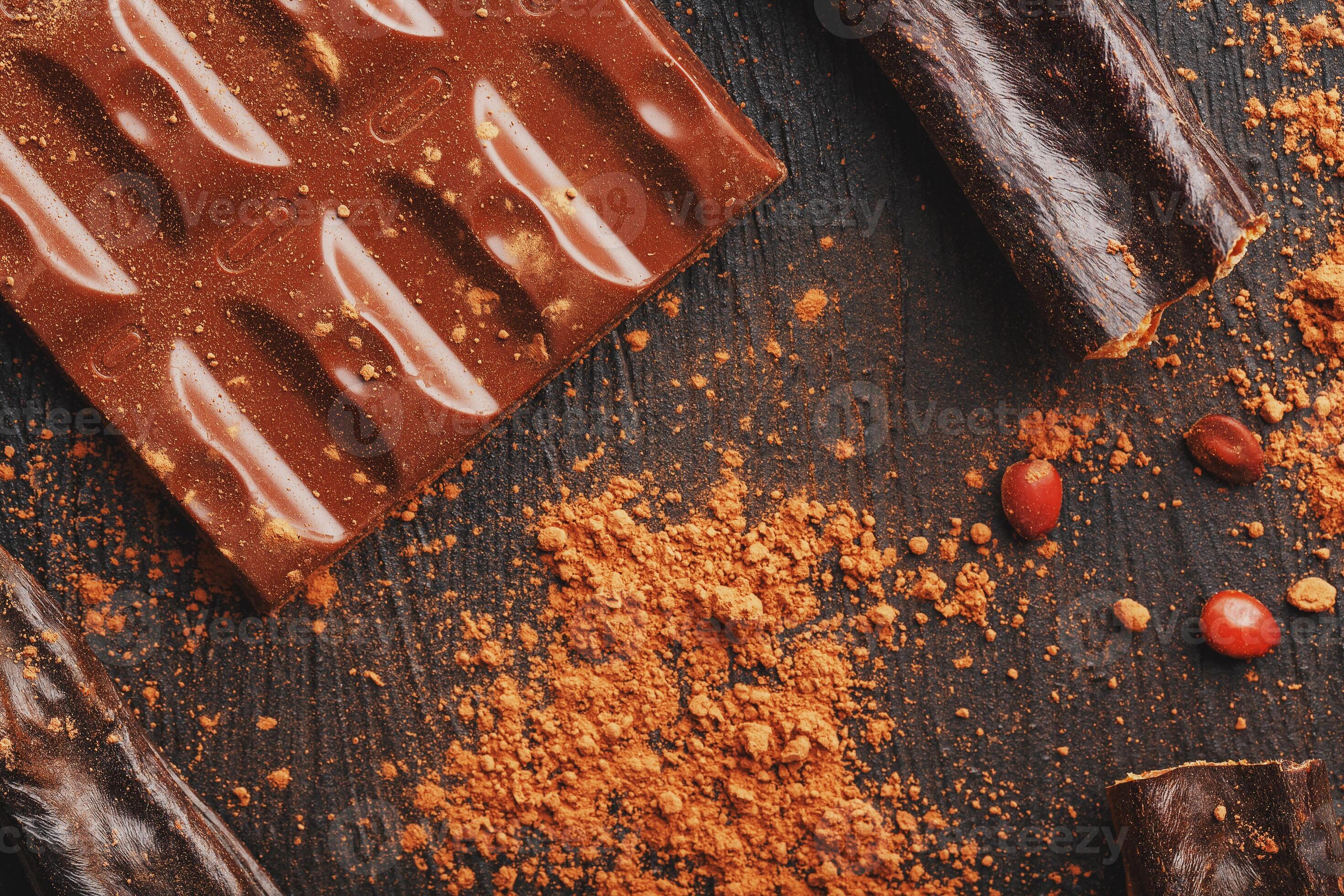 Carob chocolate and carob fruit powder on dark background. A tasty and