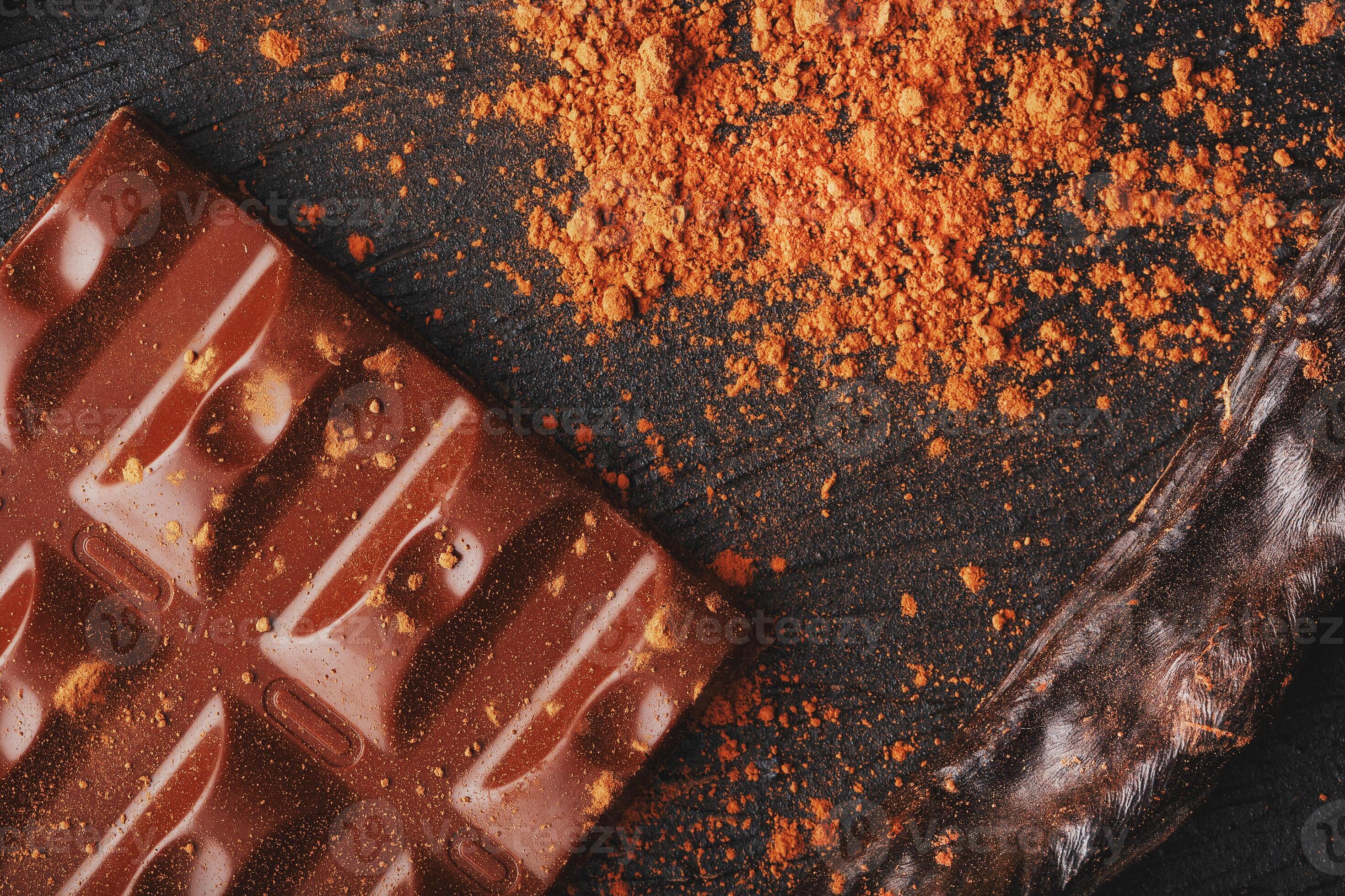 Carob chocolate and carob fruit powder on dark background. A tasty and