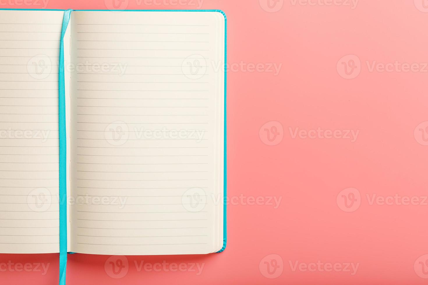 Open a laptop with blank pages on a pink background. Top view, copy space photo