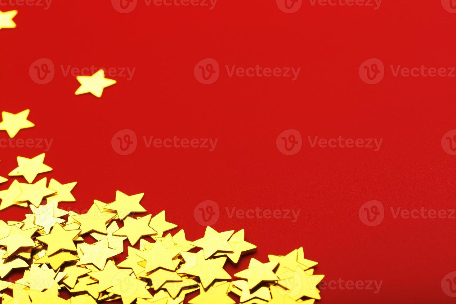 A scattering of Gold stars on a red background. Greeting cards, headlines and website concept. photo