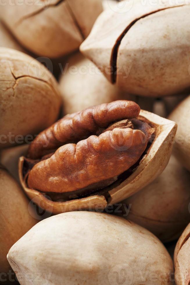 Pecan nuts close-up, macro as the background on the whole screen. Peeled, in a shell. photo