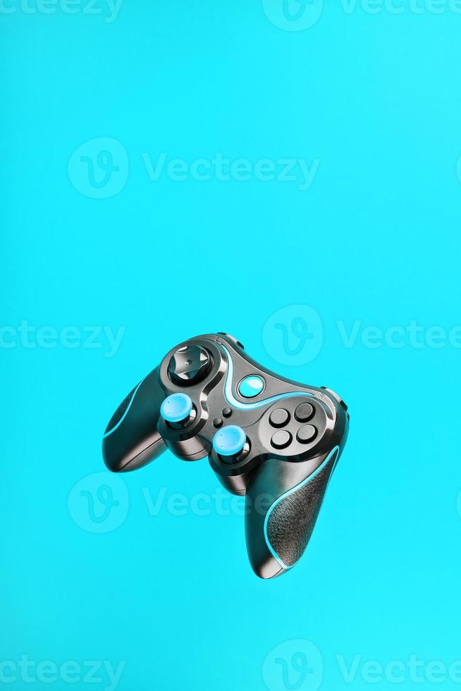 Game controller gamepad with blue buttons on cyanide background. photo