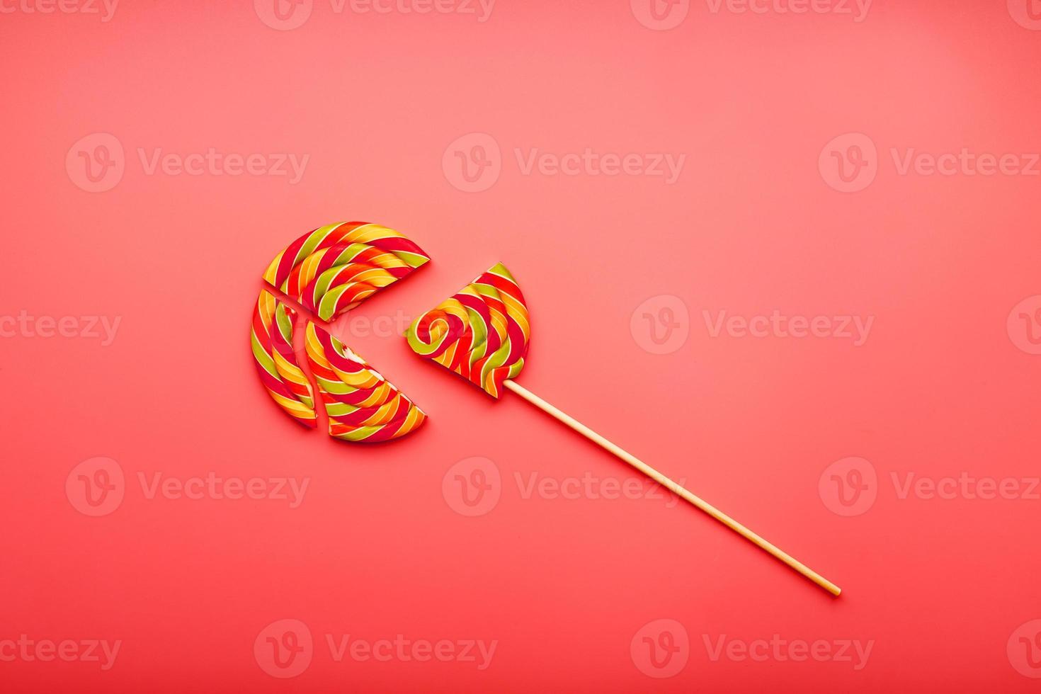 Lollipop broken into pieces on pink background, top view with copy space. photo