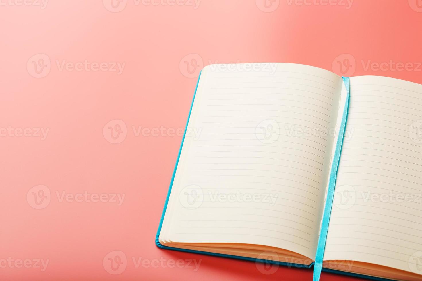 Open a laptop with blank pages on a pink background. Top view, copy space photo