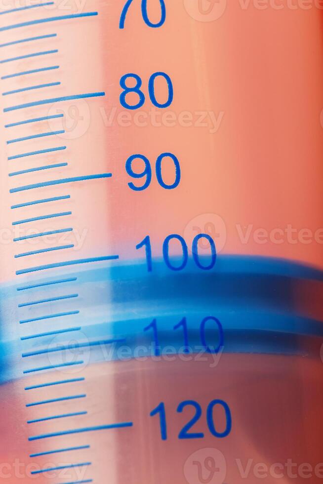 Large medical syringe on pink background with scale, copy space