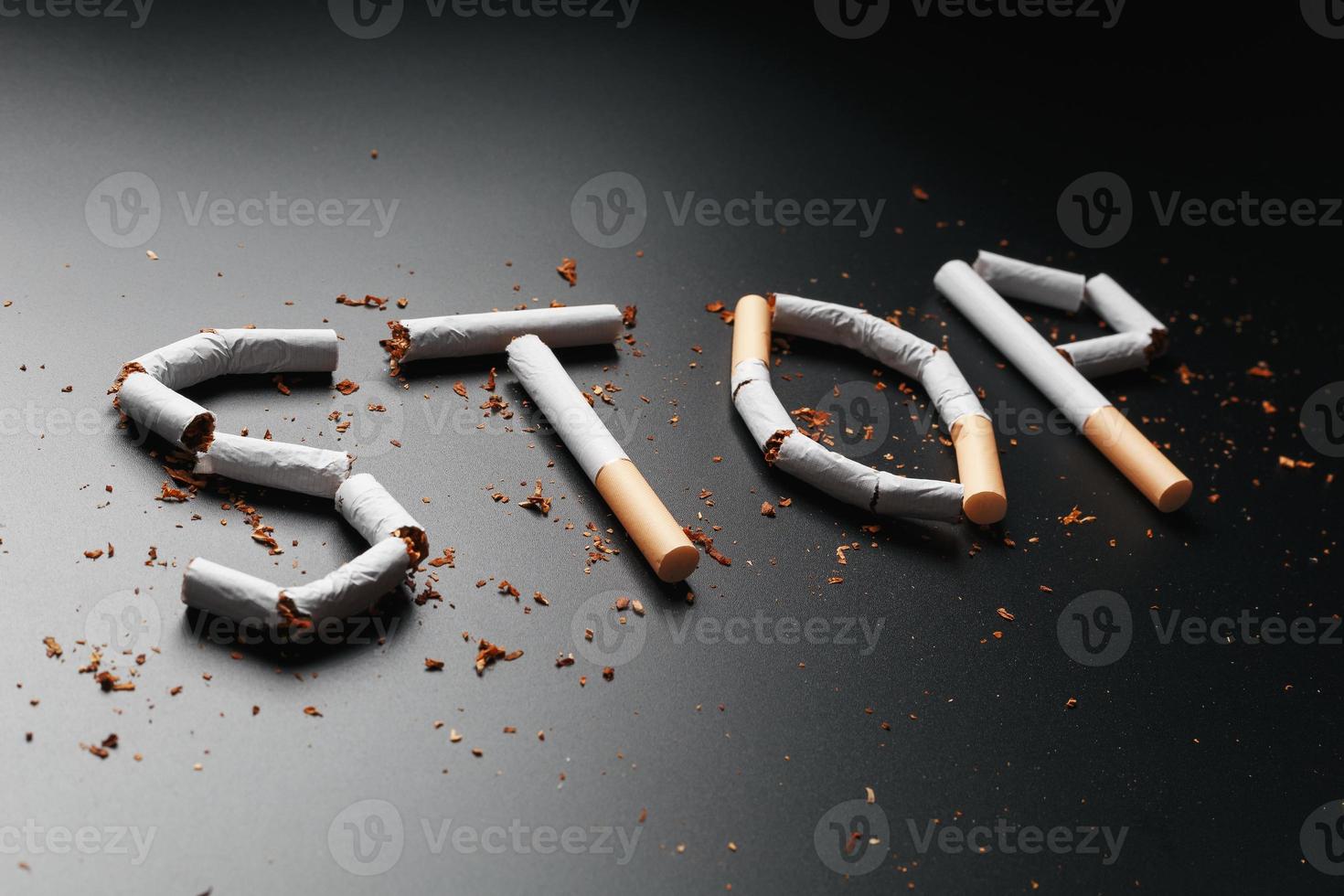 The inscription STOP from cigarettes on a black background. Stop smoking. The concept of smoking kills. Motivation inscription to quit smoking, unhealthy habit. photo