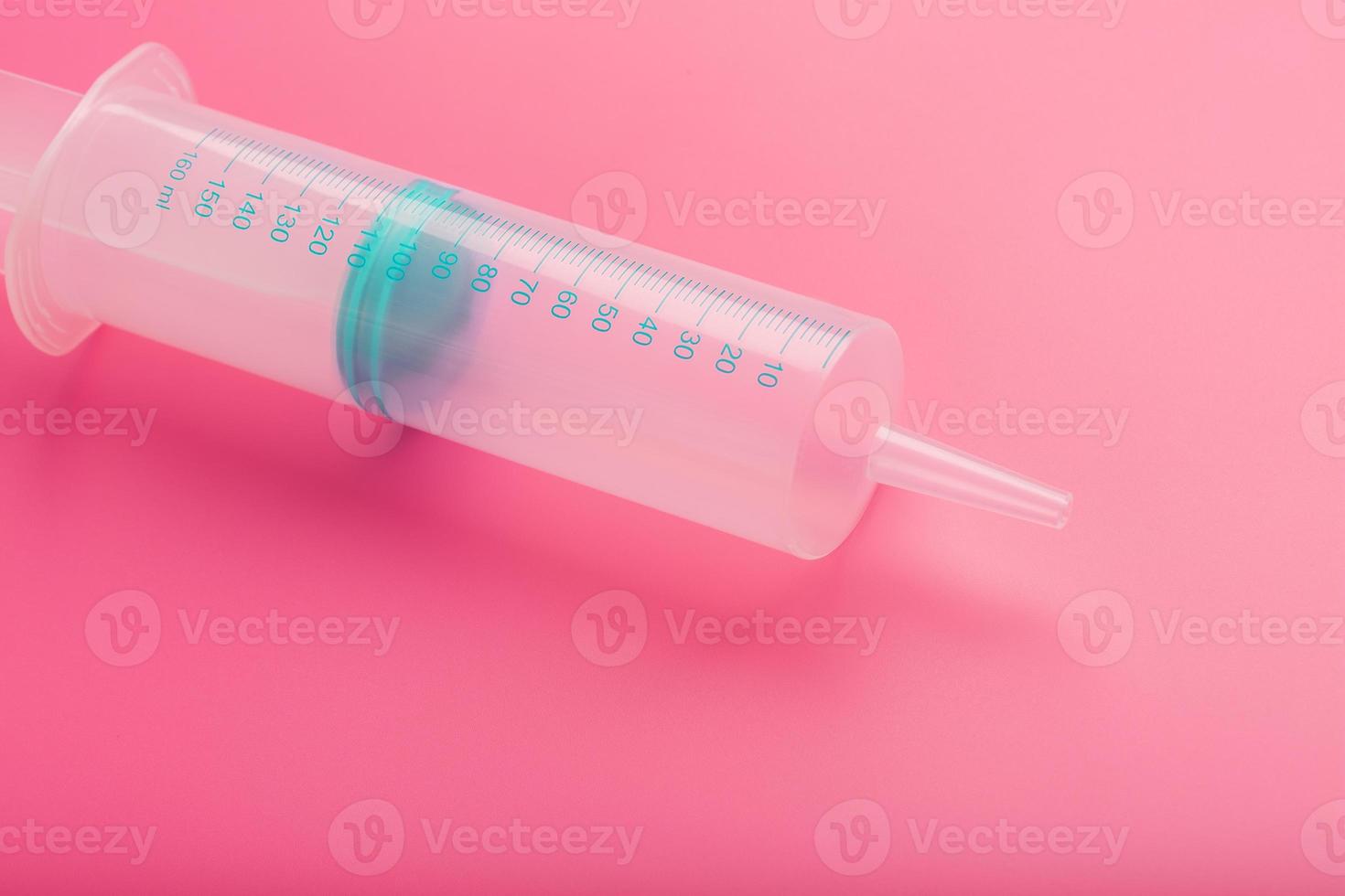 Syringe on pink background close-up, copy space. T photo