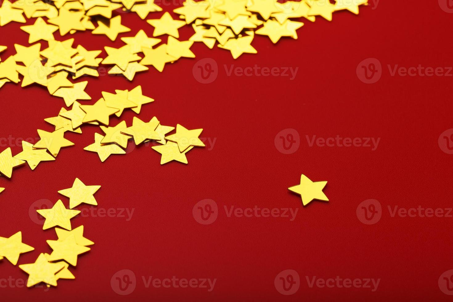 Gold stars on red background. The concept of greeting cards, headlines and web site. A scattering of Golden stars photo