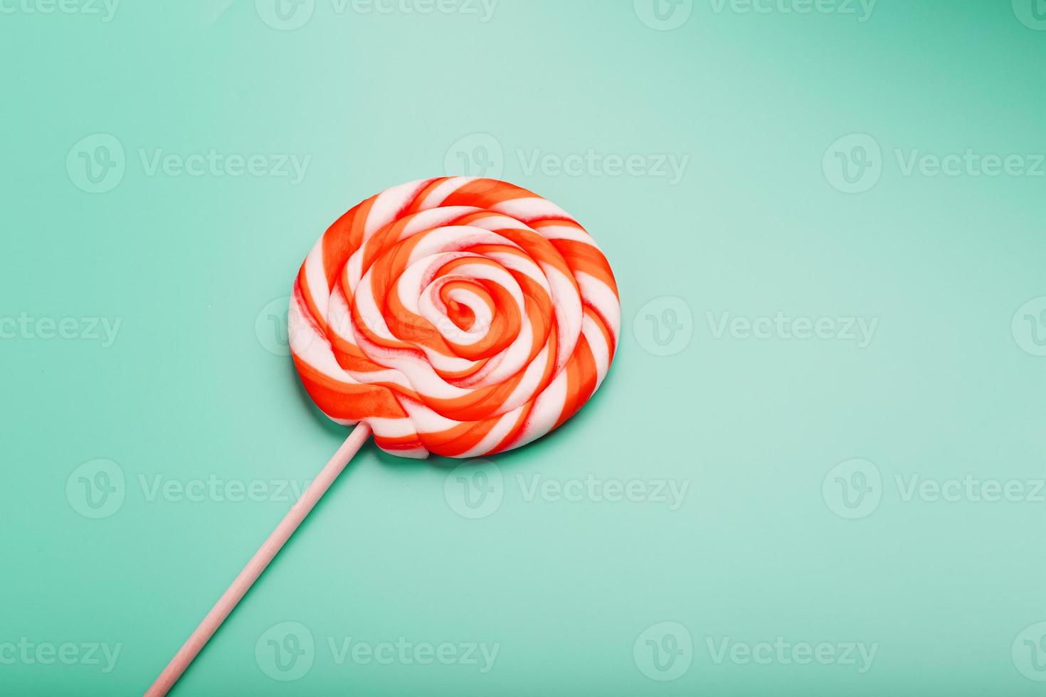 Orange round Lollipop on blue background. Minimal concept with copy space. photo