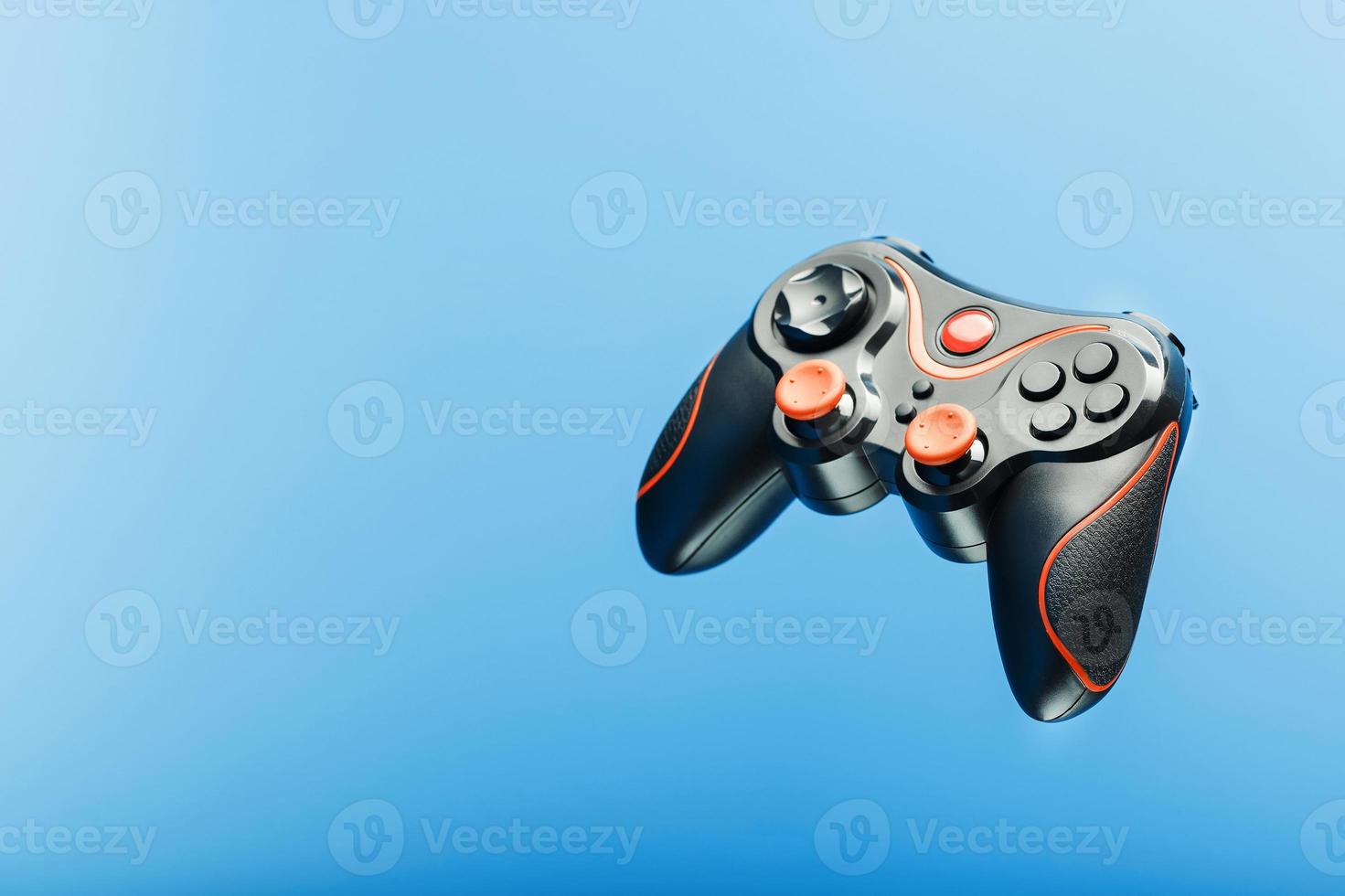 Black gamepad on a black red background, . Gaming concept. photo