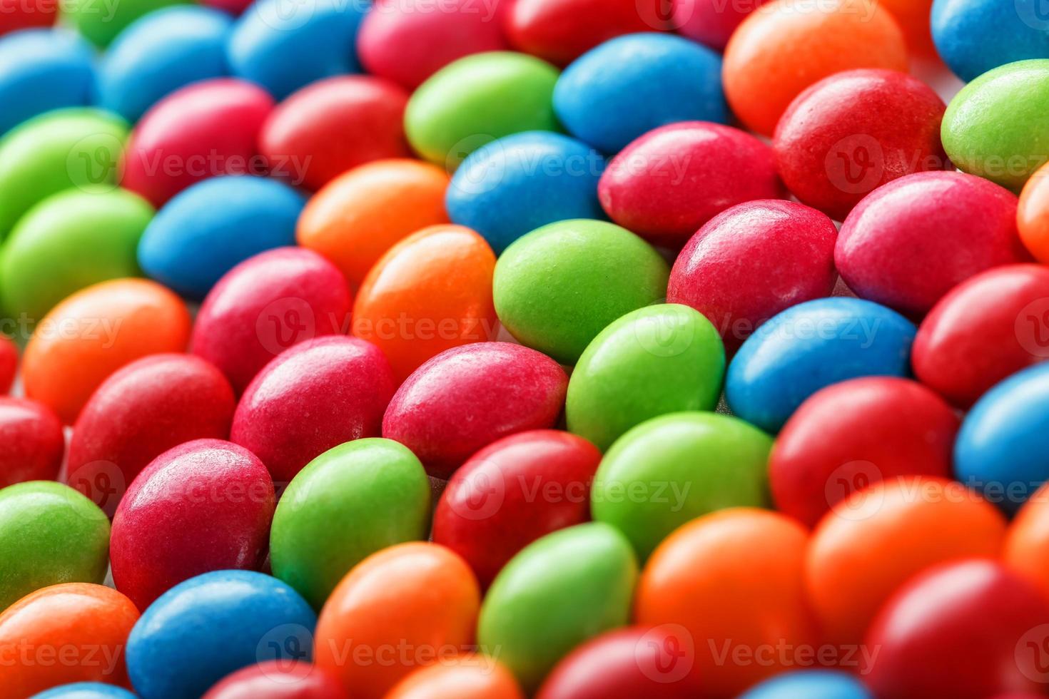 Rainbow colors of multicolored candies close-up, texture and repetition of dragee photo