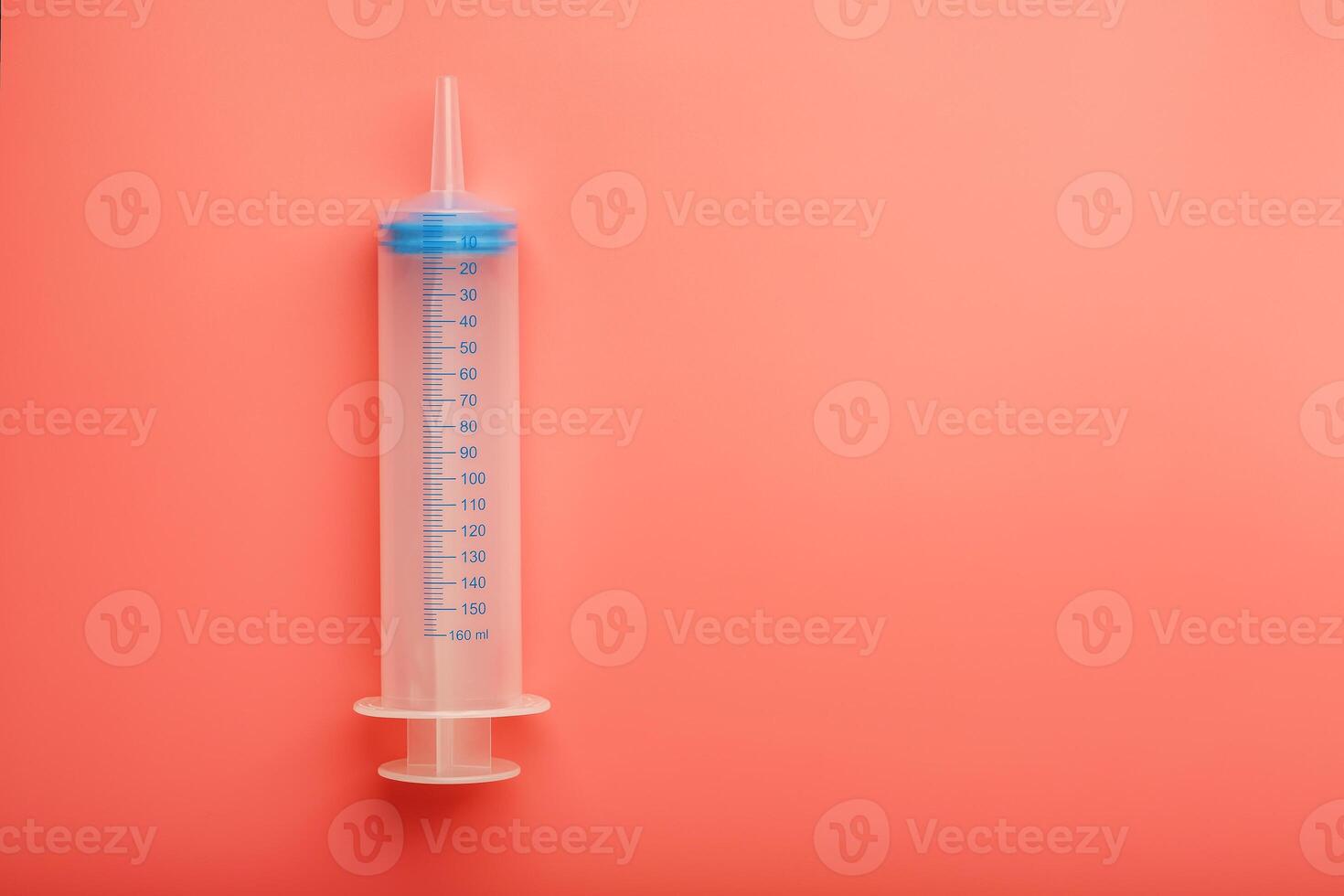 Large medical syringe on pink background with scale, copy space