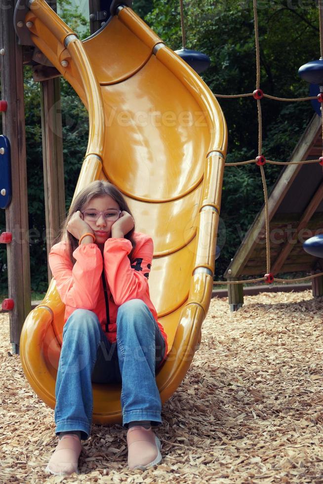 Teenage Girl is Sadly Alone in the Playground photo