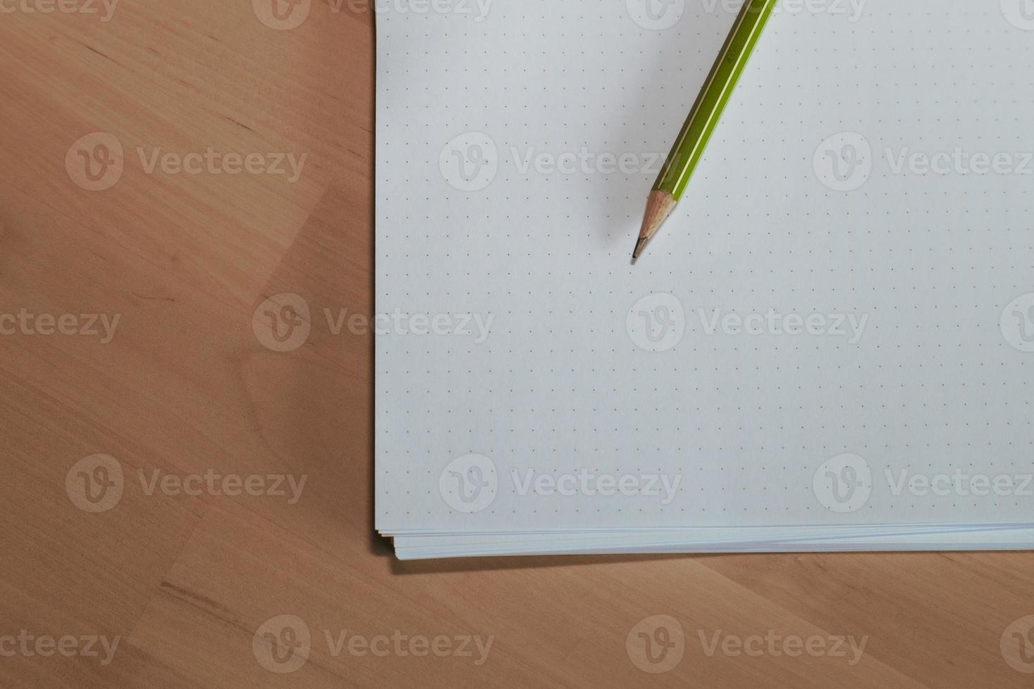 Paper with pencil on wooden table. Pencil on table, the blogger instrument photo