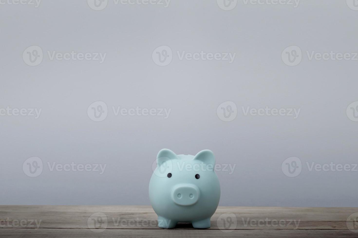 Blue piggy bank with copy space for you text on table background photo