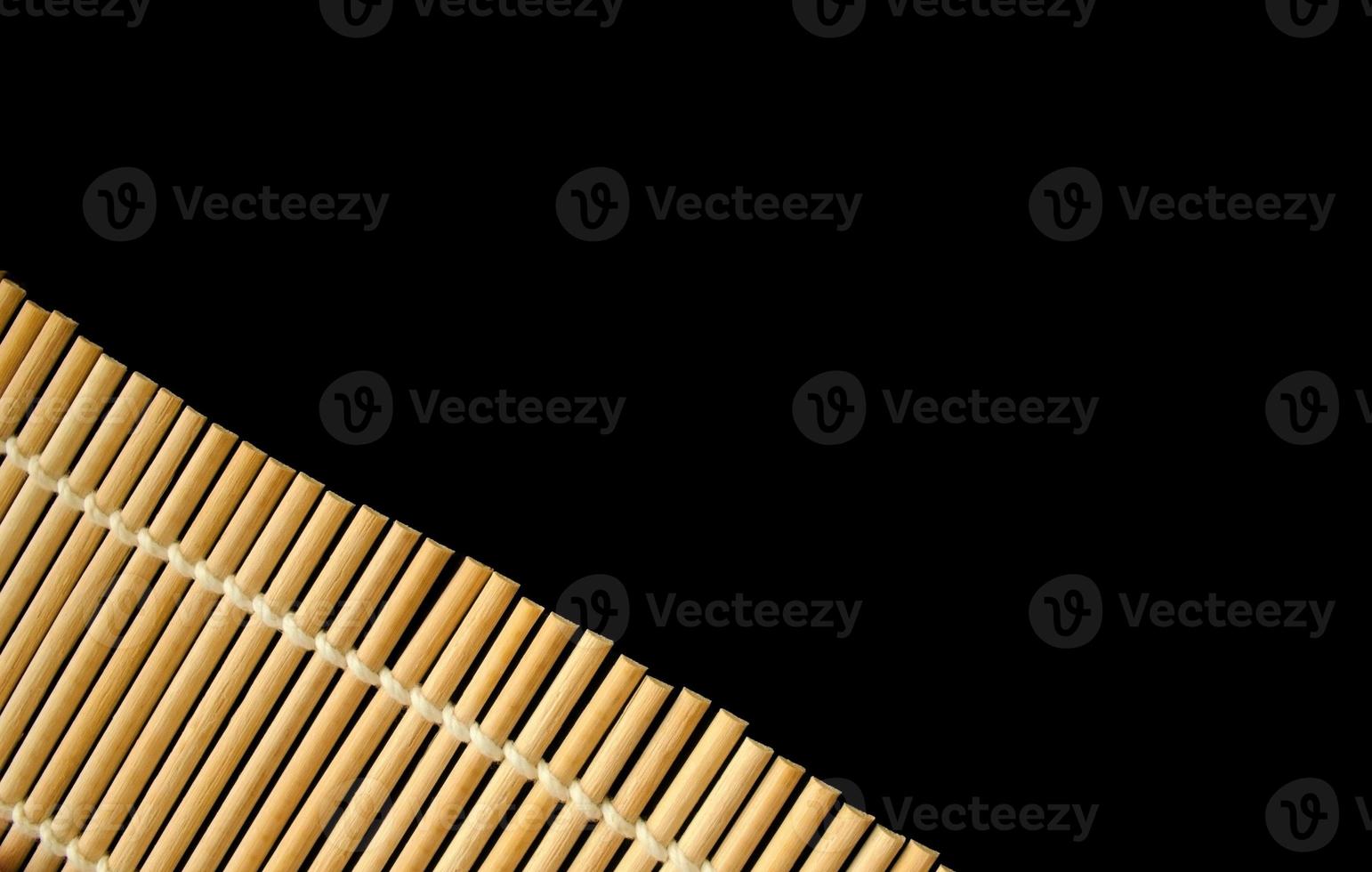 bamboo roller mat for cooking sushi on black background. copy space for text photo