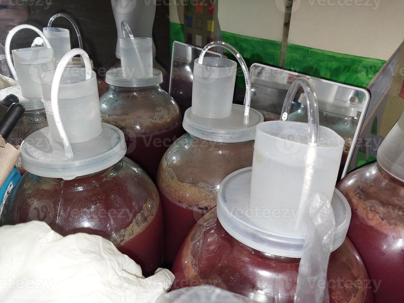 Fermenting homemade wine in cans closed with a water seal photo