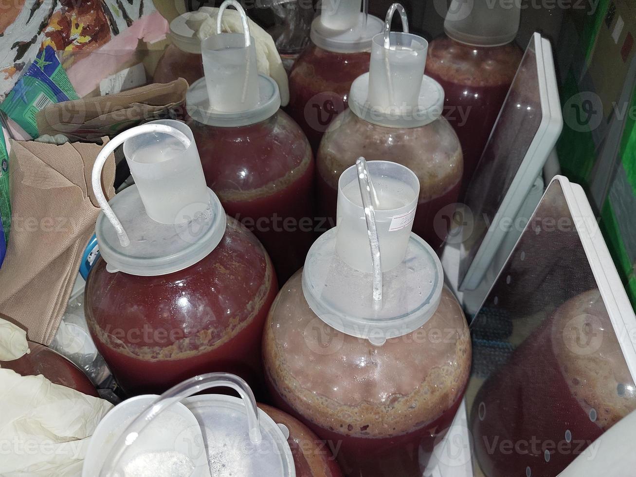 Fermenting homemade wine in cans closed with a water seal photo