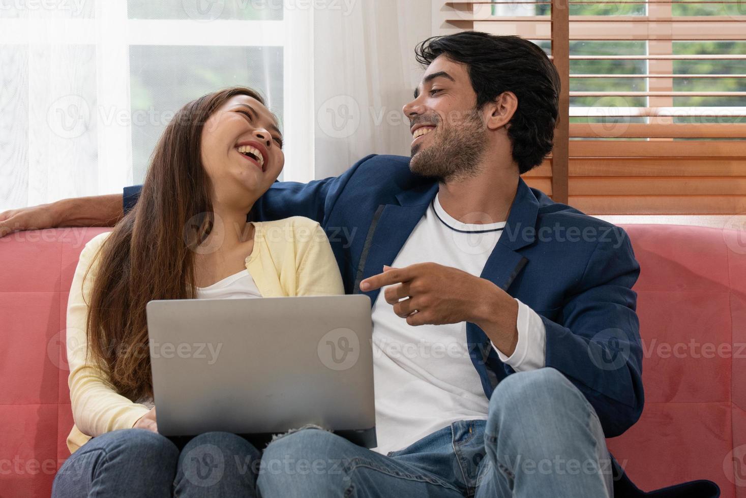 joven pareja birracial viendo películas desde la computadora juntos en casa foto