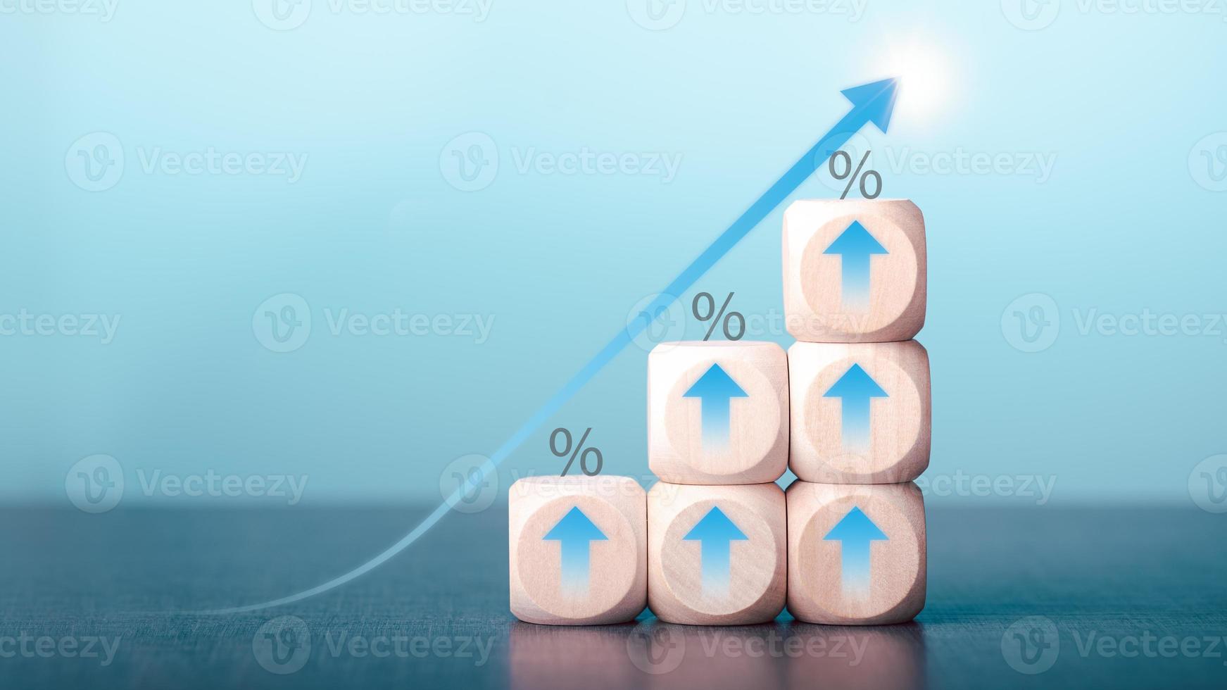 tasas de interés financieras y tasas de interés hipotecarias, la economía está mejorando, un bloque de madera con una flecha apuntando hacia arriba, porcentaje de crecimiento de la inversión, buena señal gráfica de tendencia financiera foto