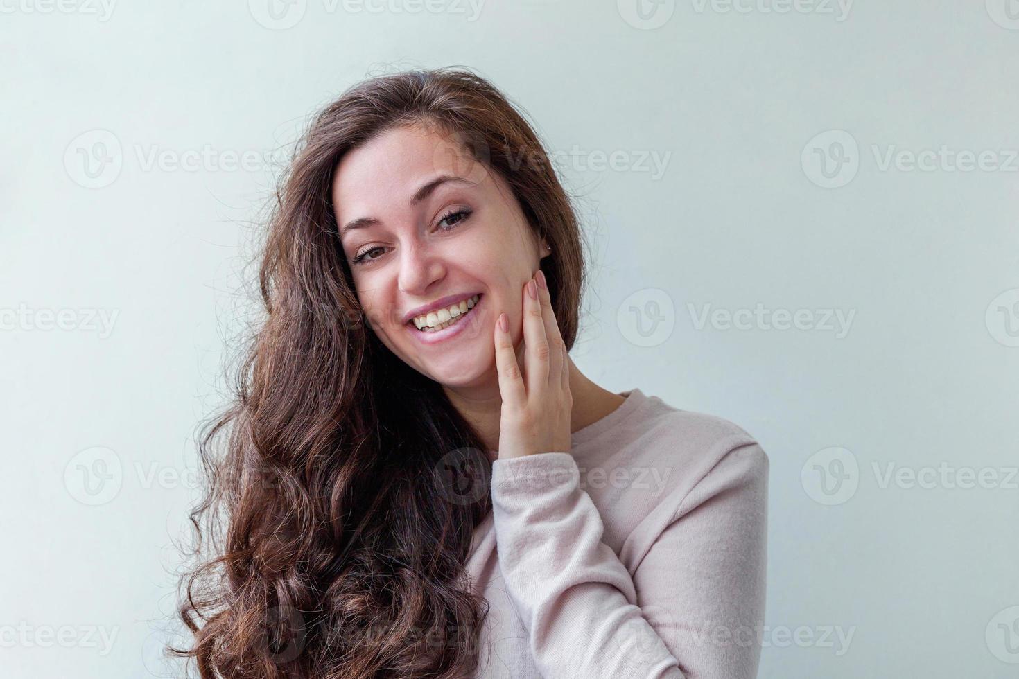 niña feliz sonriendo. retrato de belleza joven feliz mujer morena risa positiva sobre fondo blanco aislado. mujer europea. emoción humana positiva expresión facial lenguaje corporal. foto