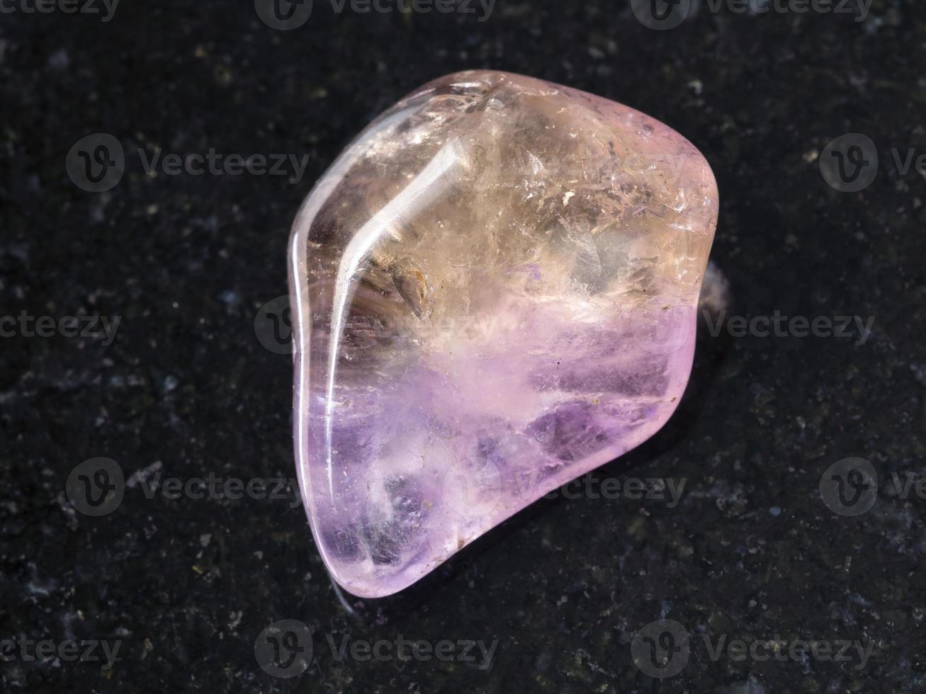 tumbled Ametrine gemstone on dark background photo