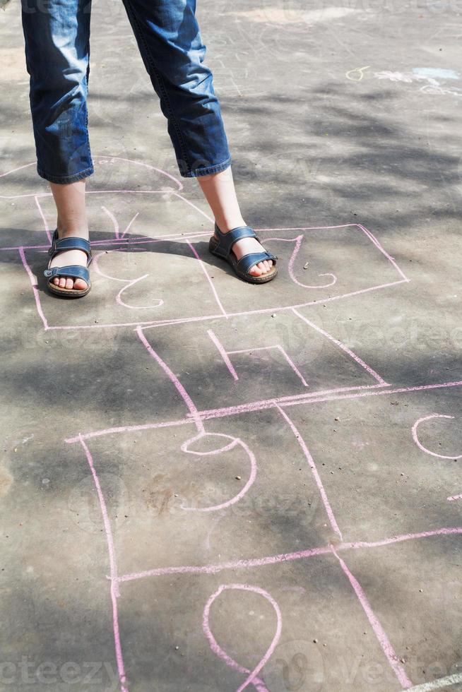 niña jugando a la rayuela al aire libre foto