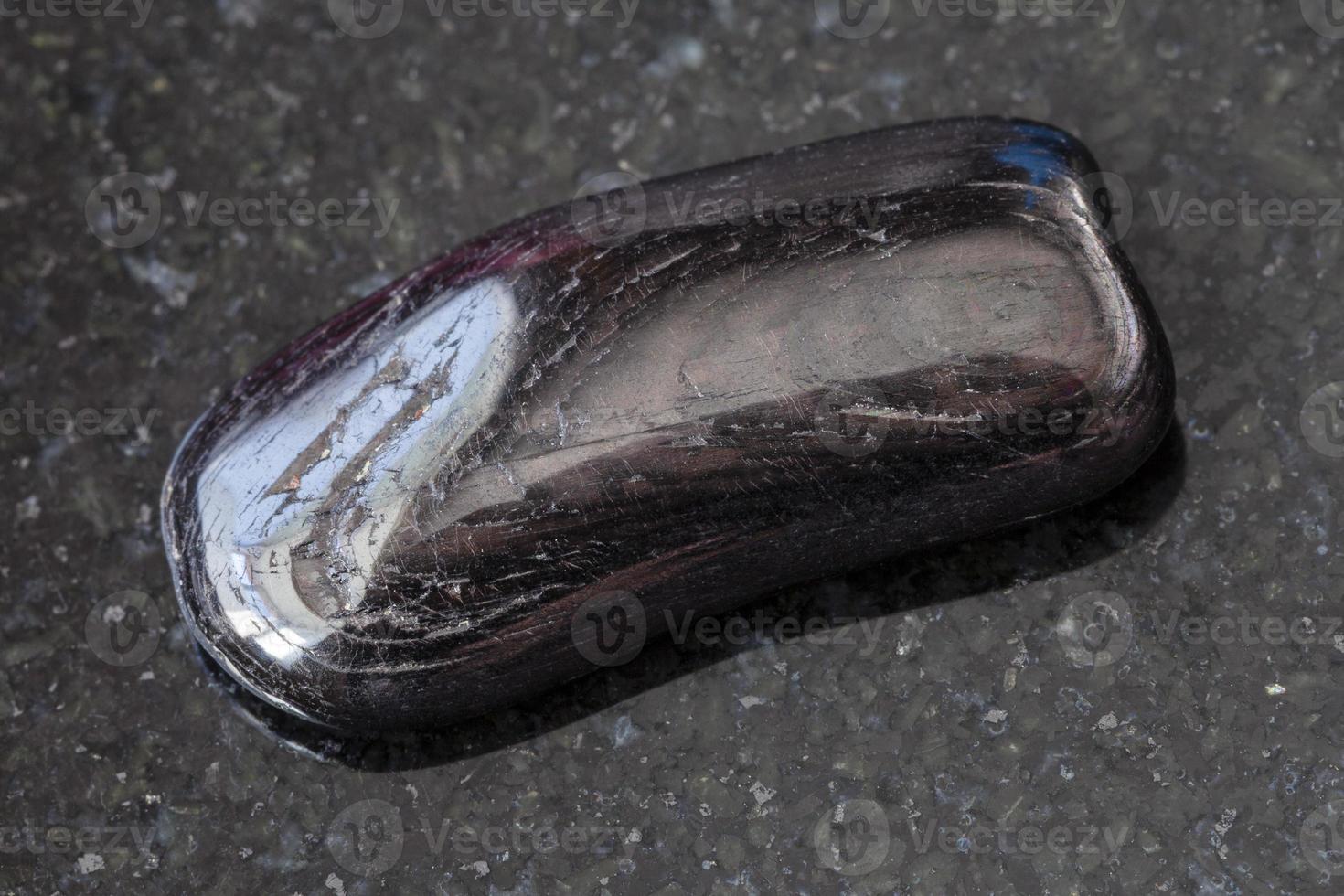 Hypersthene gemstone on dark background photo