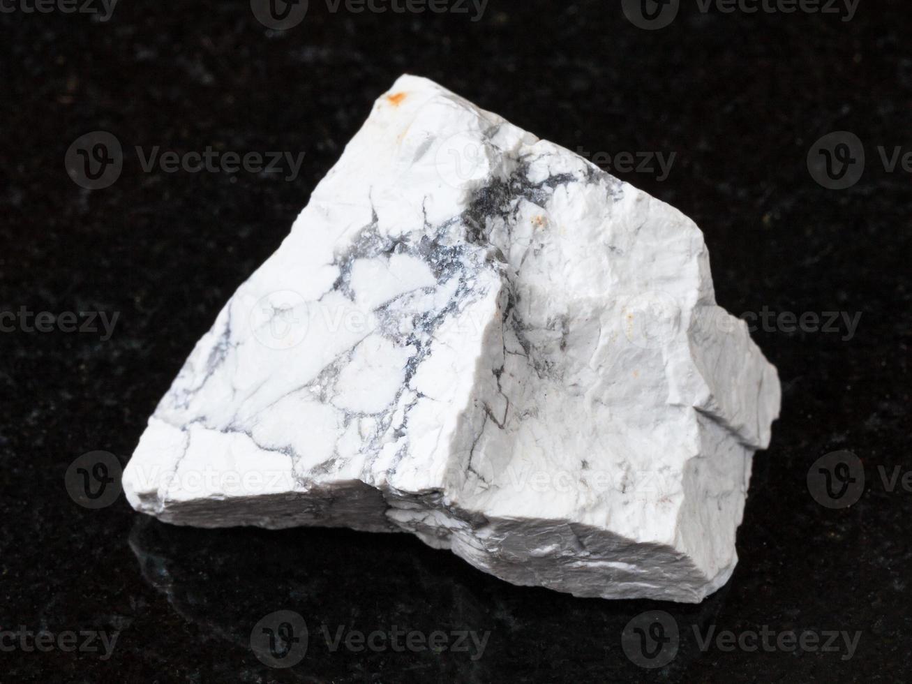 white Howlite stone on black granite photo
