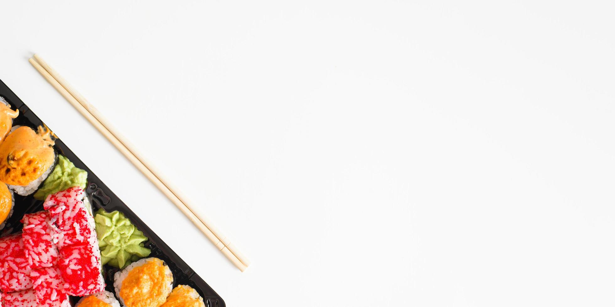 Japanese traditional food banner, copy space. Set of sushi and rolls and chopsticks, top view. photo