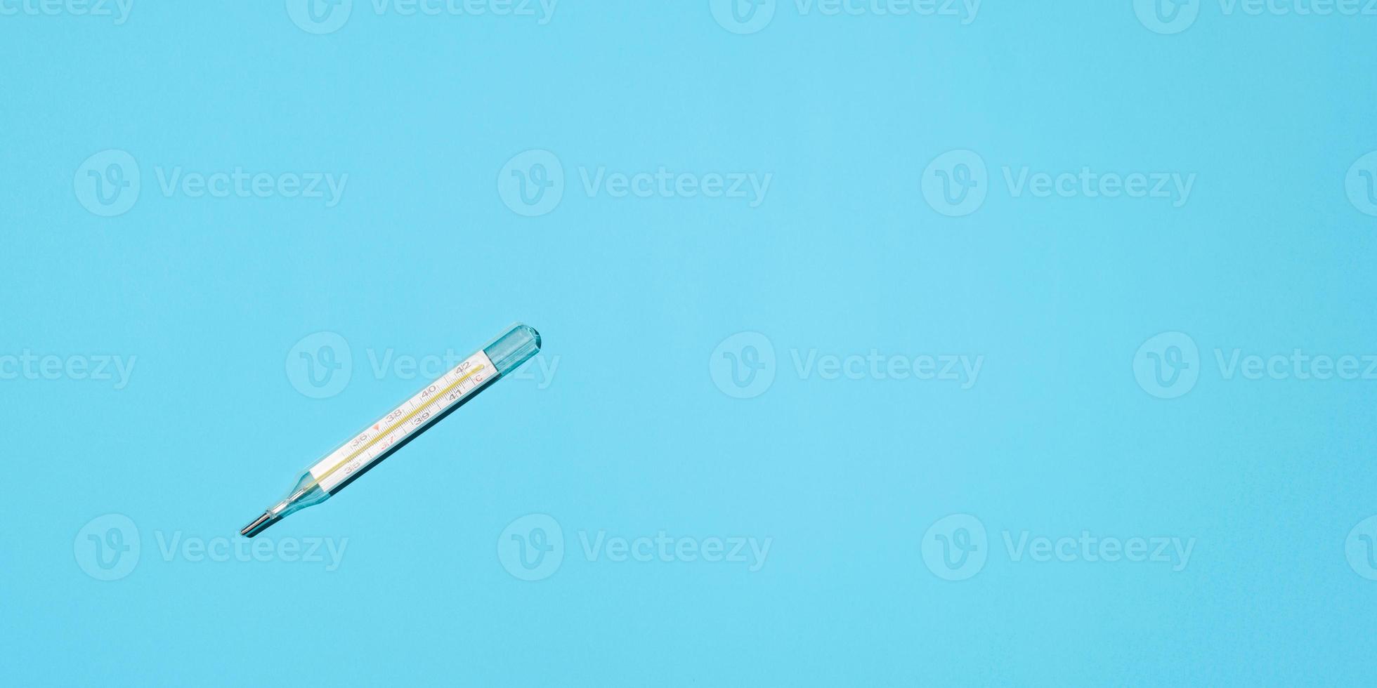 Celsius thermometer lying on a blue background, flat lay. Banner, place for text photo