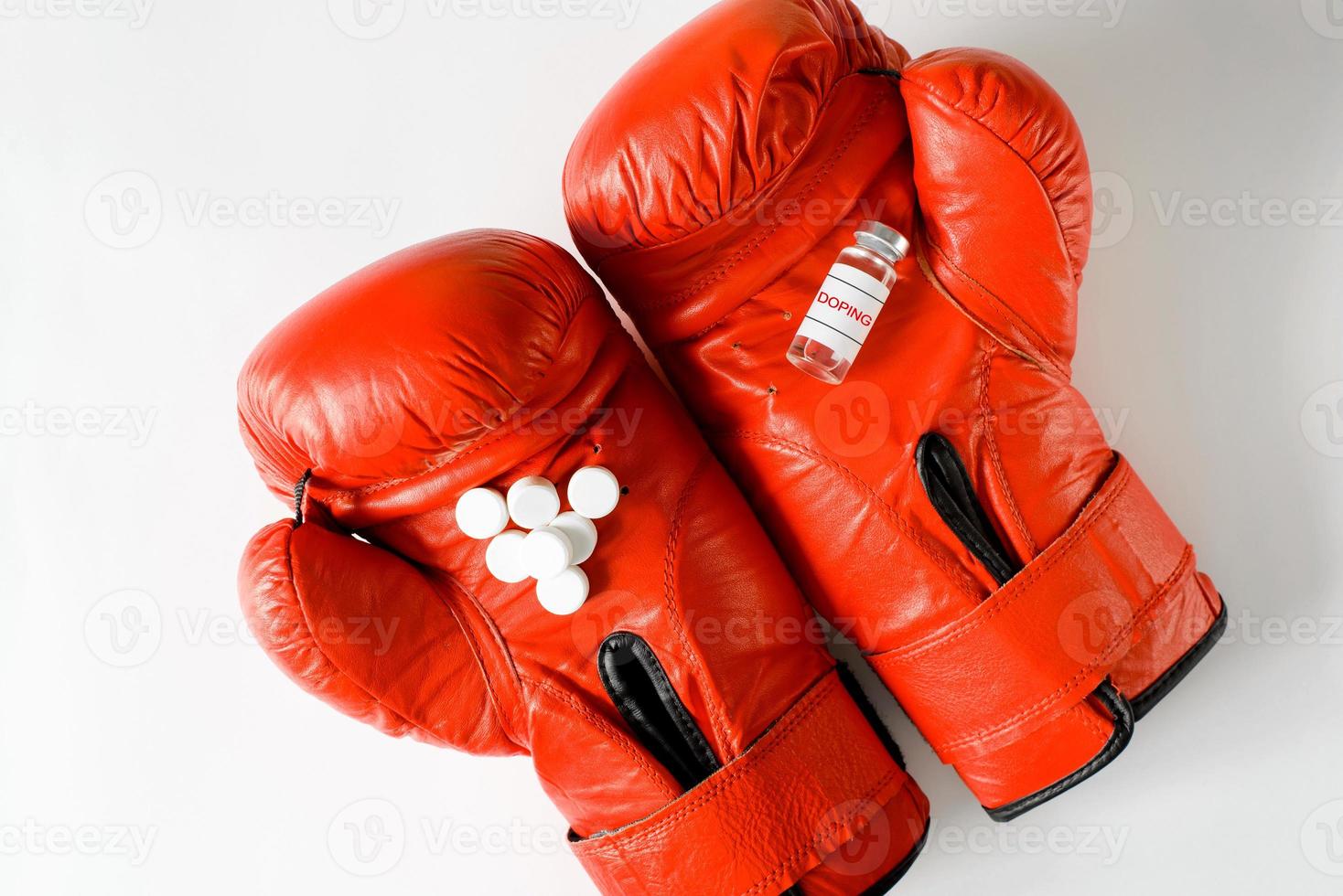 Bottle of drugs and pills lying on boxing gloves, flat lay. Doping, pharmacology and sports concept. photo