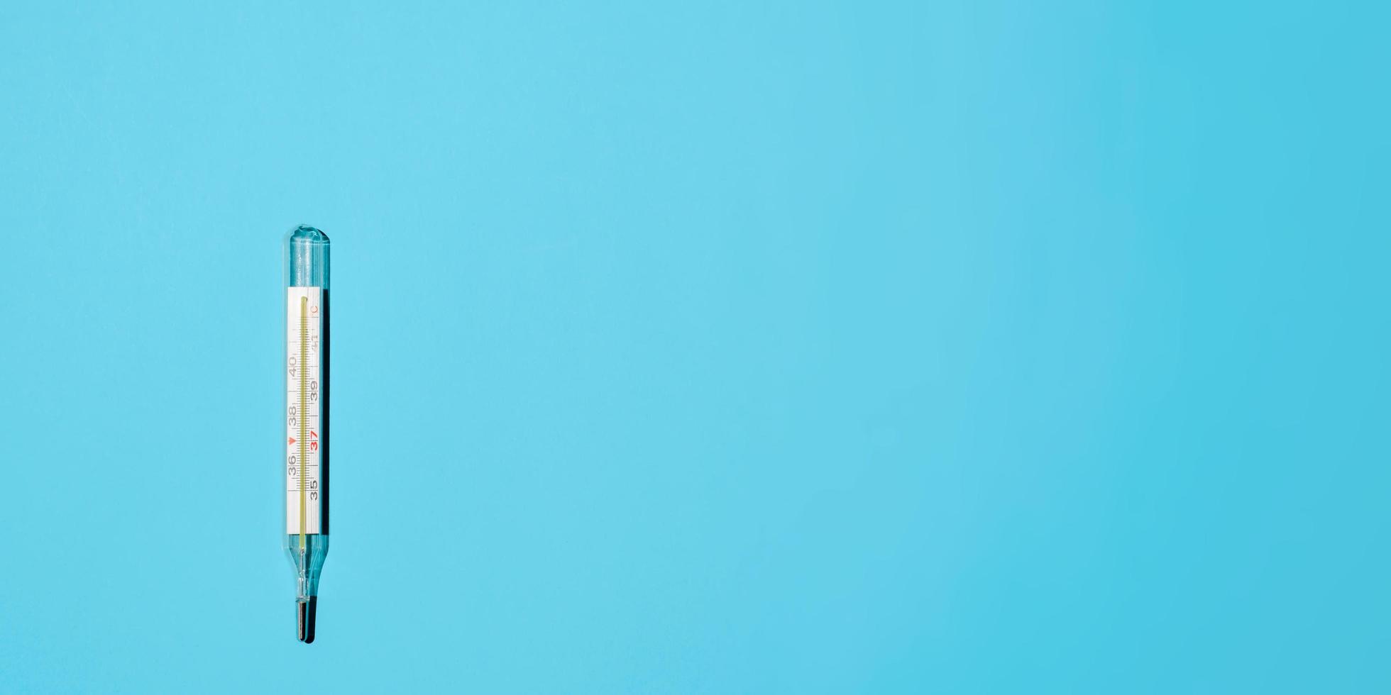Classic Celsius thermometer on a light blue background, flat lay. Banner, space for text on the right. Medical minimalist photo