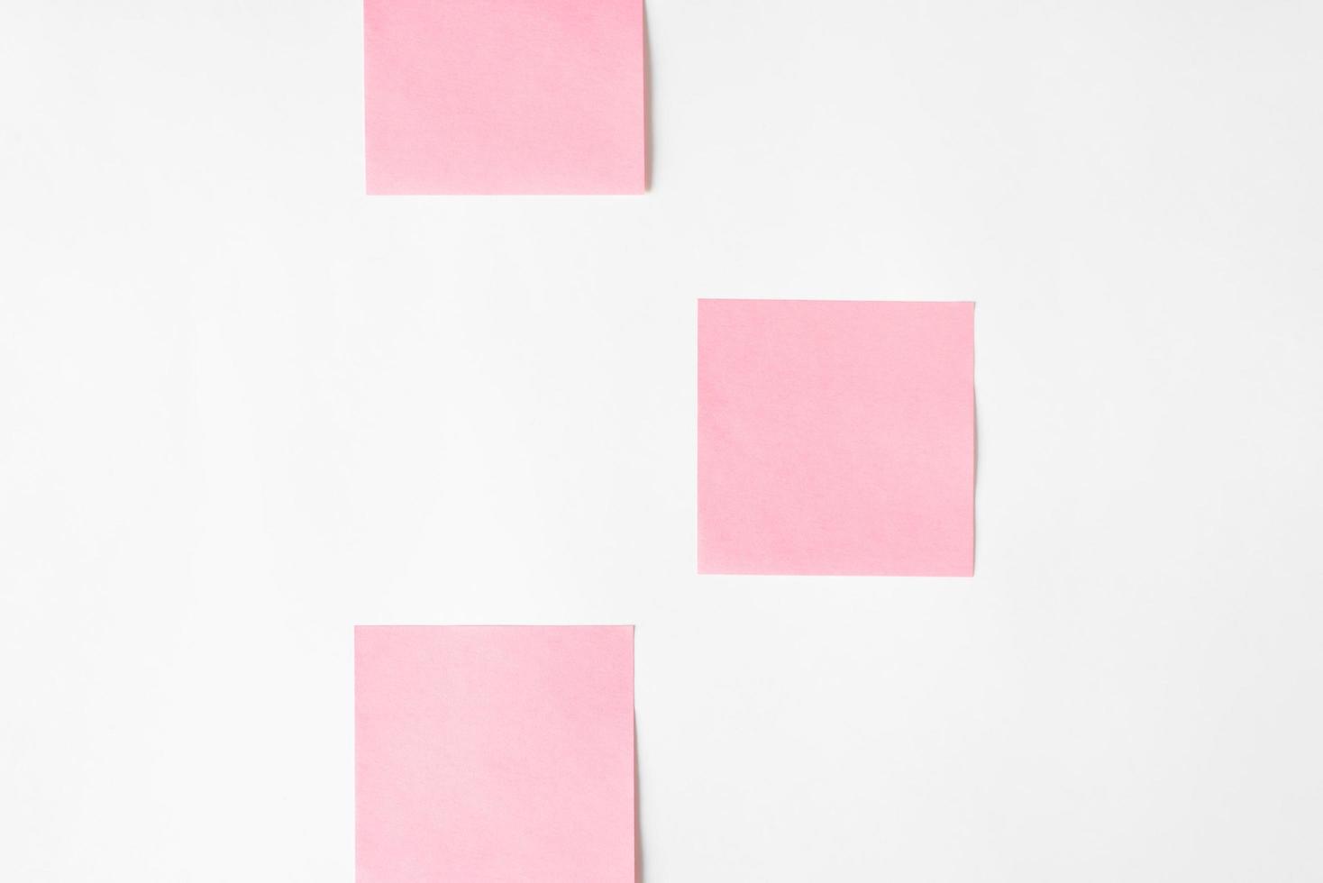 Pink stickers on a white wall, copy space. Layout reminder photo