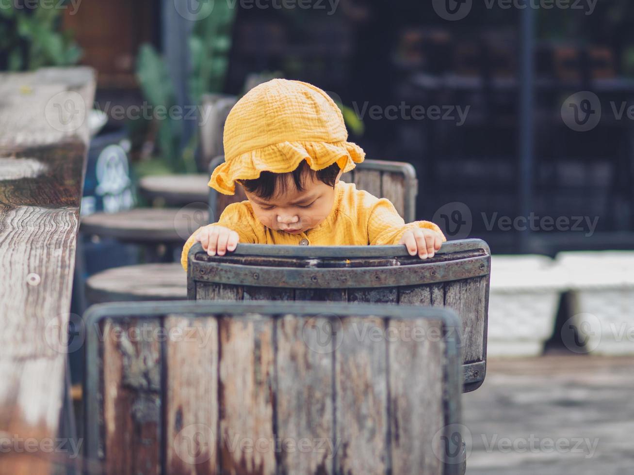 Asian baby of Thai nationality on vintage chair at De mala Cafe, Thung Saliam, Sukhothai, Thailand. photo