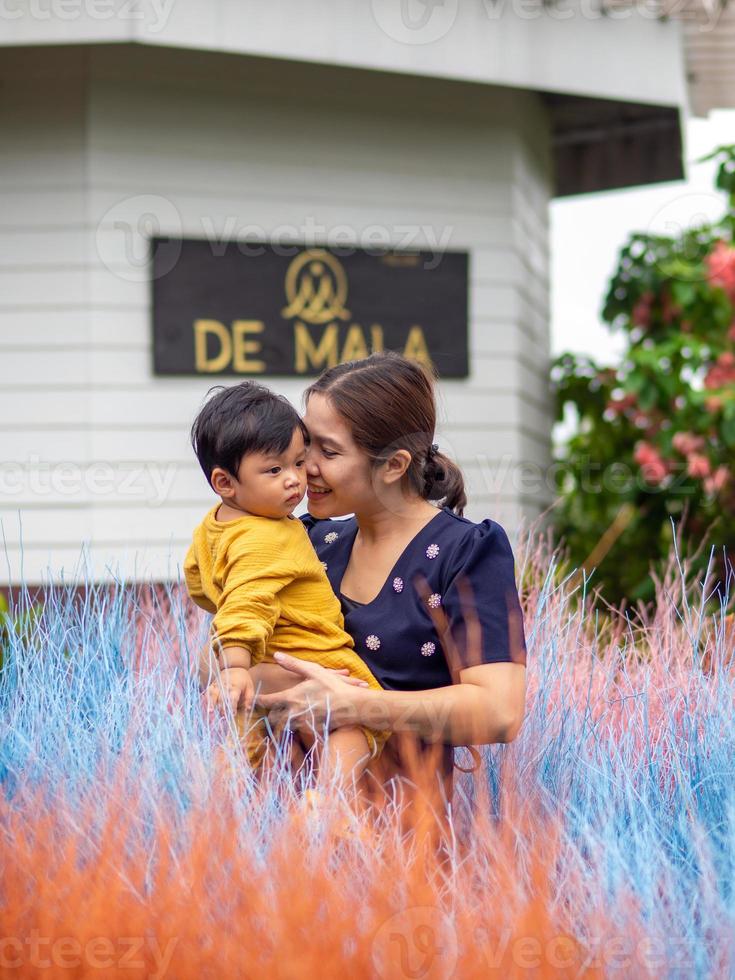 Asian mother and son of Thai nationality and colorful grass at De mala Cafe, Thung Saliam, Sukhothai, Thailand. photo