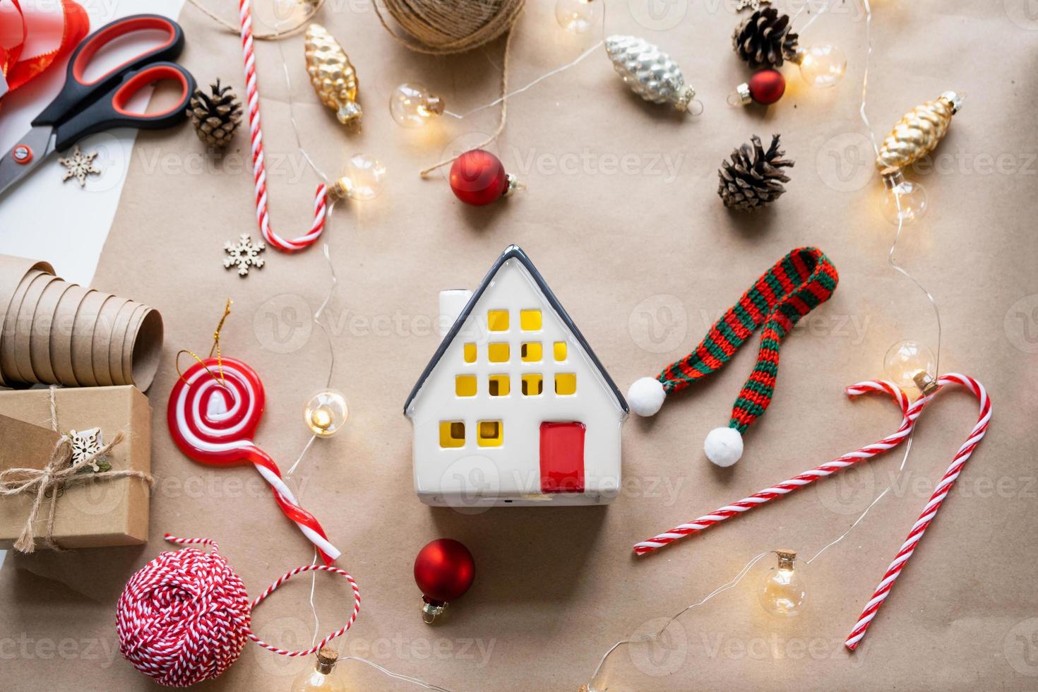 Cozy house in Christmas decor layout, warm knitted scarf, hat, winterization. Winter, snow - home insulation, protection from cold weather, room heating system. Festive mood, Christmas, New Year photo