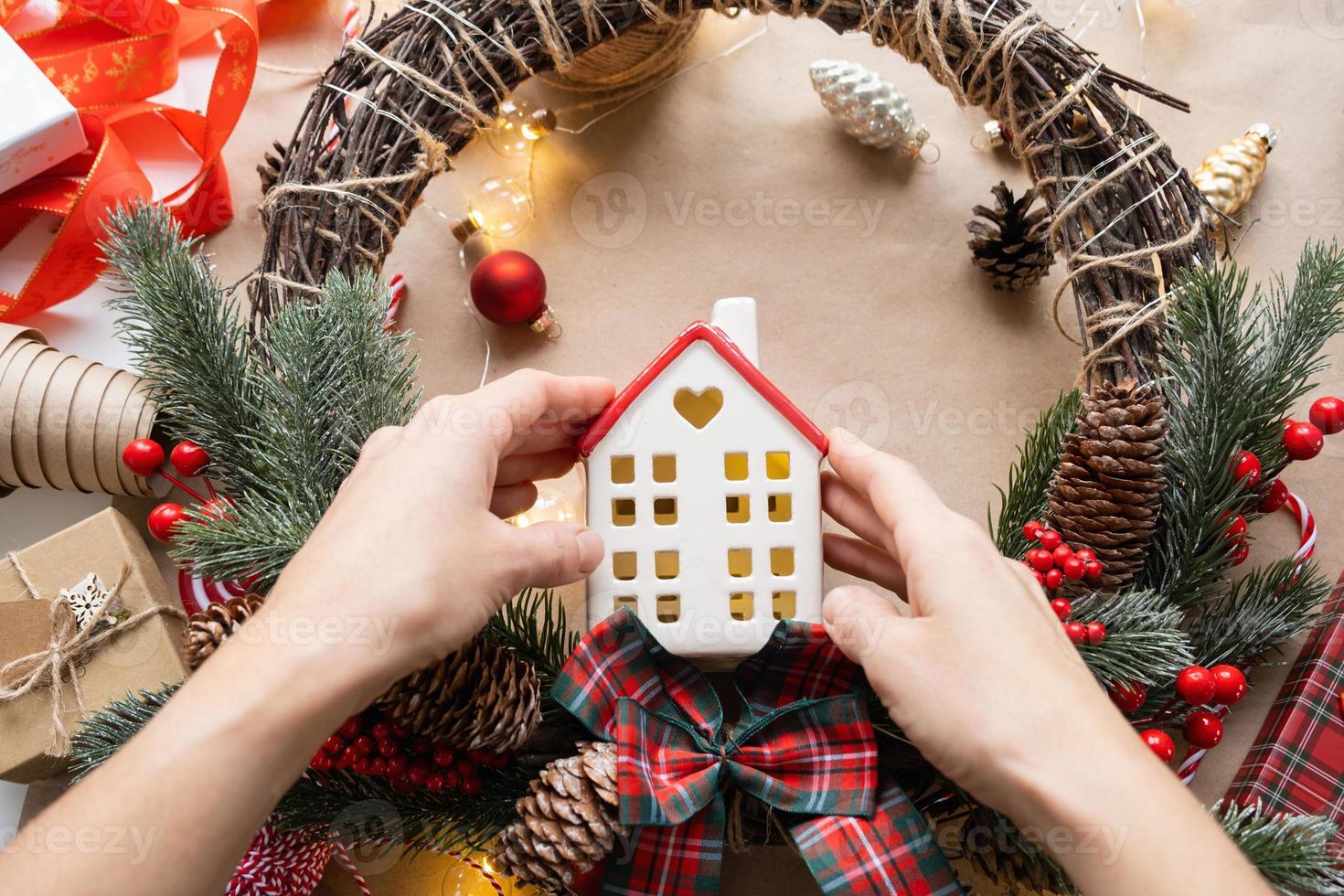 Cozy house in Christmas decor layout, warm knitted scarf, hat, winterization. Winter, snow - home insulation, protection from cold weather, room heating system. Festive mood, Christmas, New Year photo