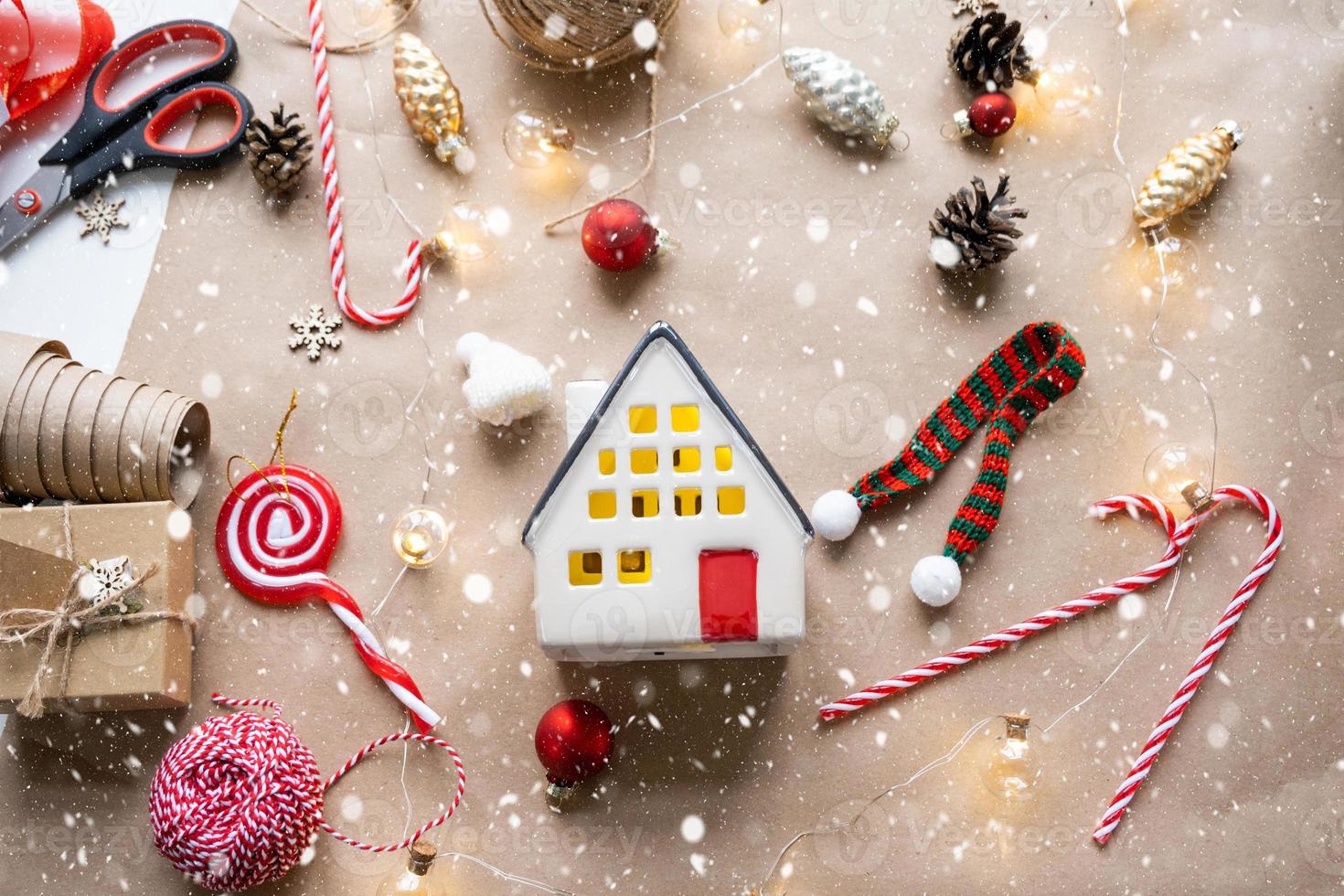 Cozy house in Christmas decor layout, warm knitted scarf, hat, winterization. Winter, snow - home insulation, protection from cold weather, room heating system. Festive mood, Christmas, New Year photo
