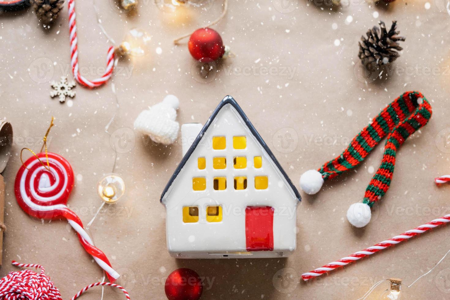 Cozy house in Christmas decor layout, warm knitted scarf, hat, winterization. Winter, snow - home insulation, protection from cold weather, room heating system. Festive mood, Christmas, New Year photo