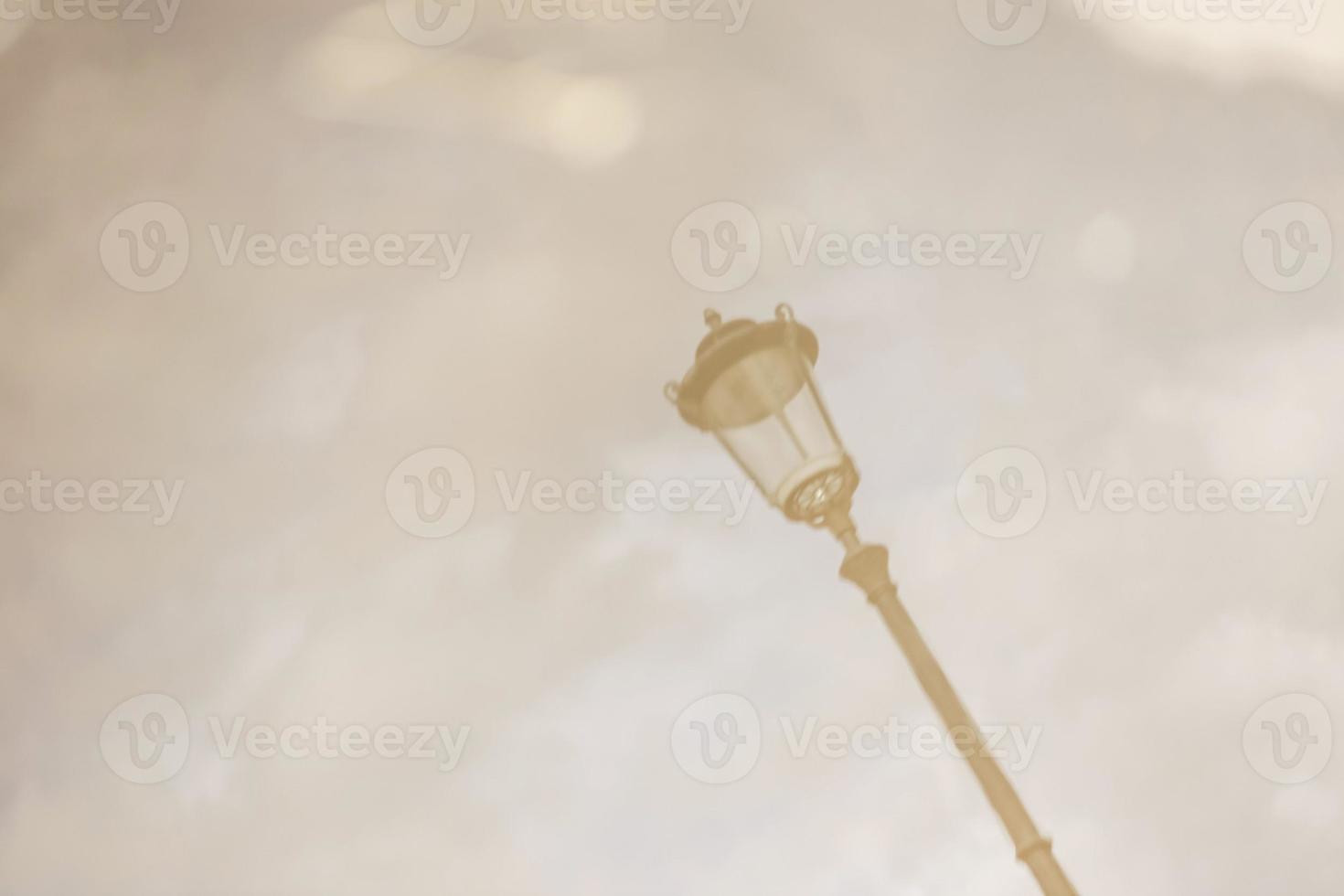 Street lamp. Reflection in a puddle against a cloudy sky in cloudy weather. Blurry image photo