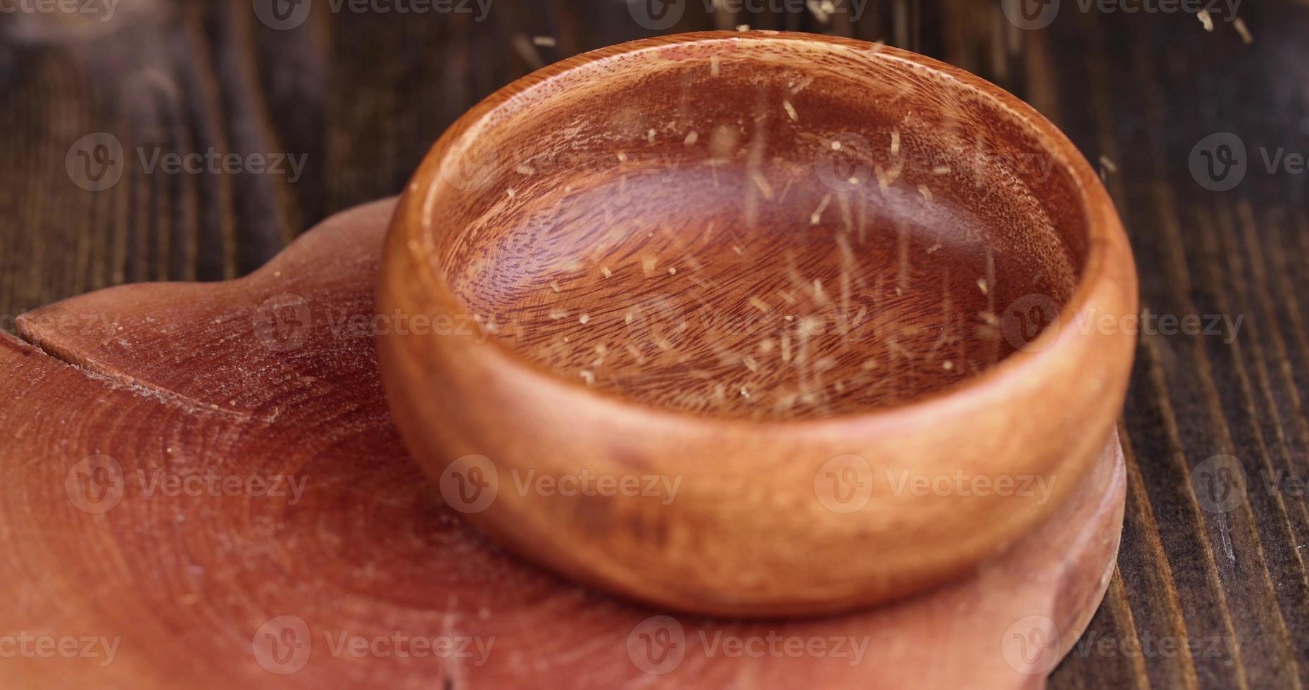 vierta azúcar de caña marrón natural en un tazón de madera foto