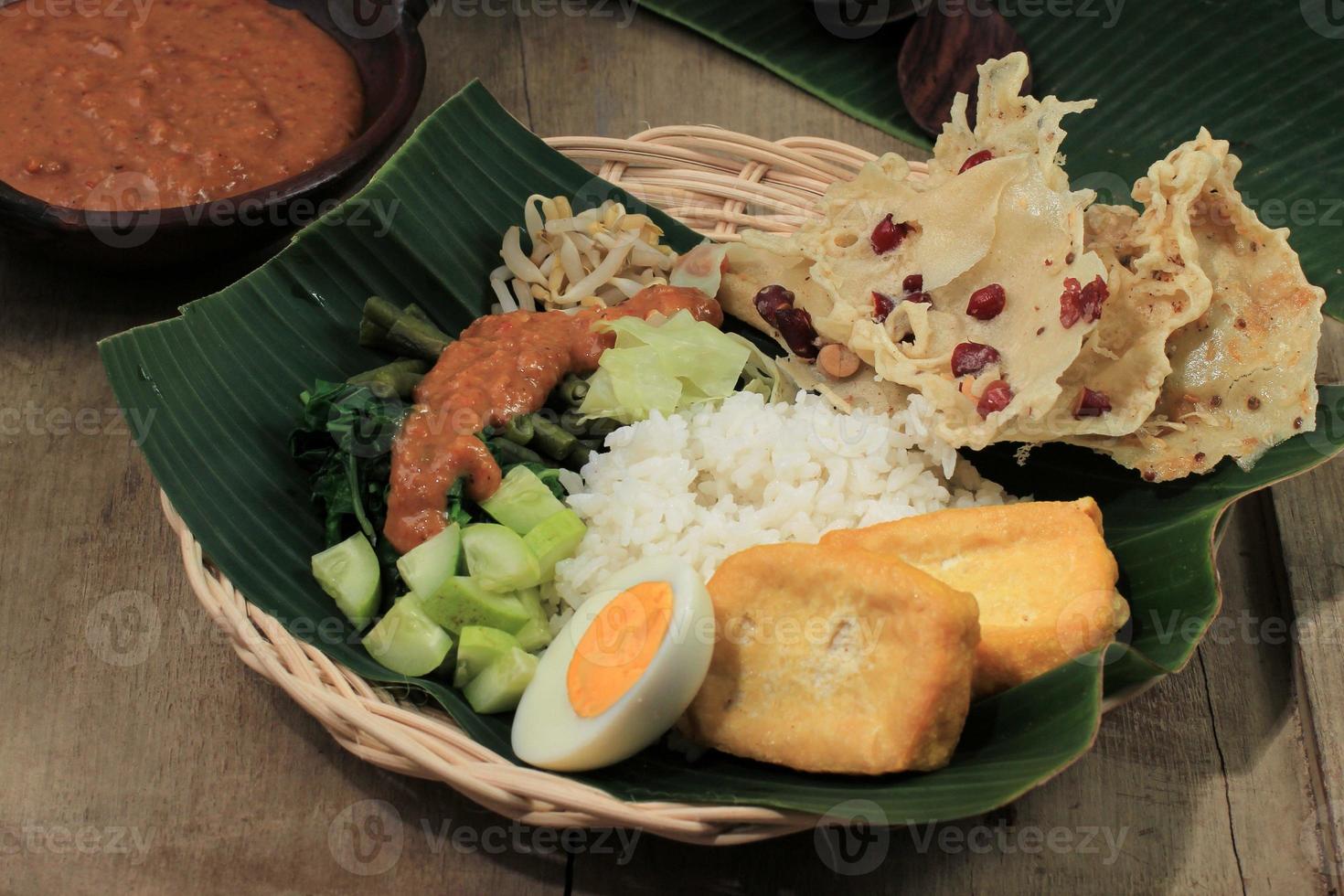 nasi pecel madiun, indonesia comida arroz y verduras con salsa de maní foto