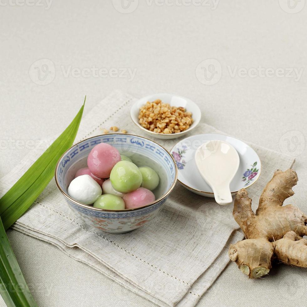 wedang ronde o tangyuan, bolas dulces glutinosas, servidas en almíbar de jengibre y mezcladas con cacahuetes tostados. foto