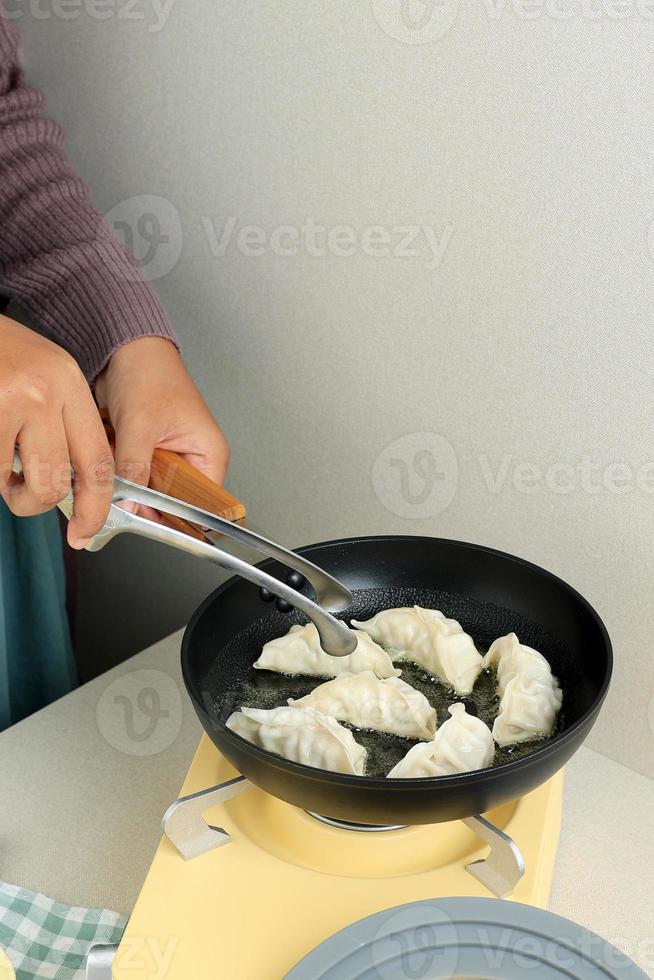 Cooking Gyoza Japanese Dumpling in Hot Oil photo