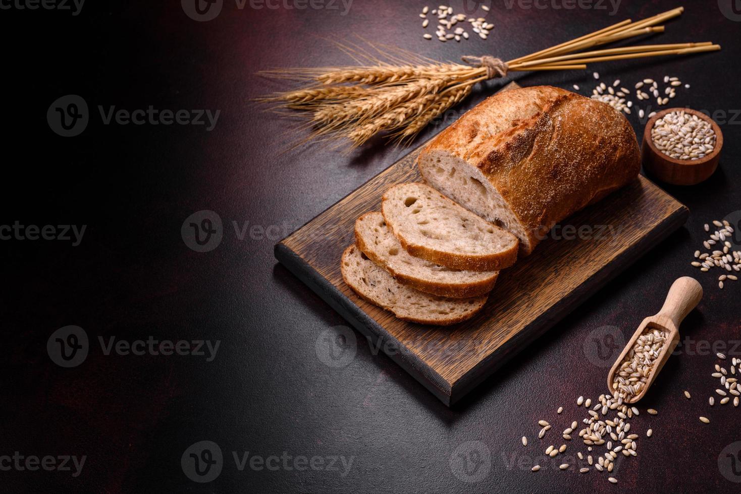 una hogaza de pan integral con granos de cereales en una tabla de cortar de madera foto