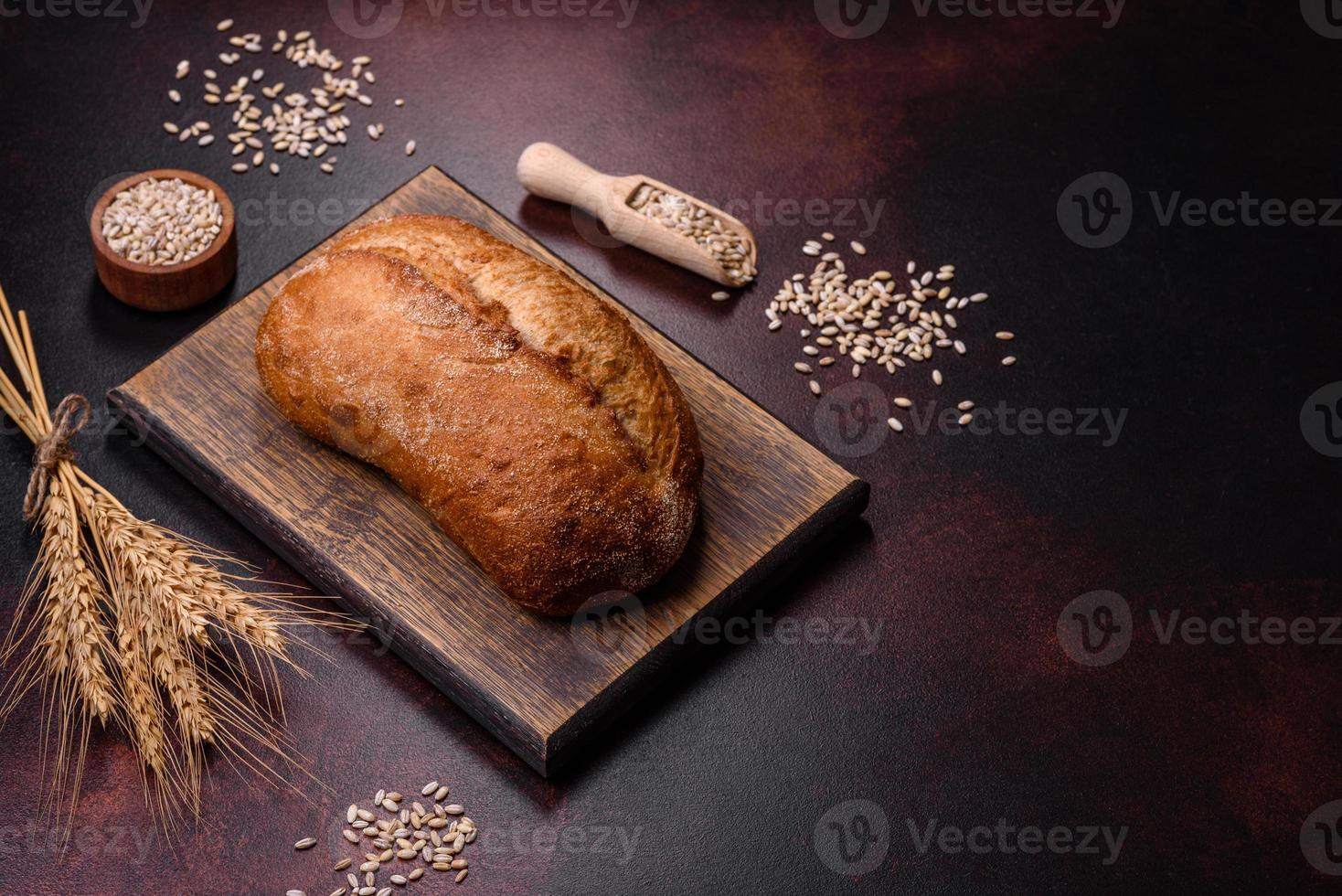 una hogaza de pan integral con granos de cereales en una tabla de cortar de madera foto