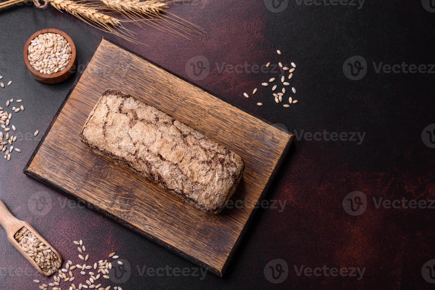 una hogaza de pan integral con granos de cereales en una tabla de cortar de madera foto
